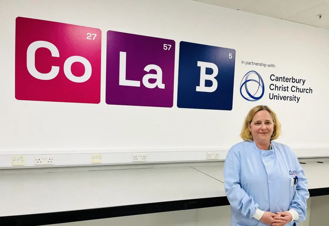 Dr Cornelia Wilson standing in front of the CoLab sign at Discovery Park